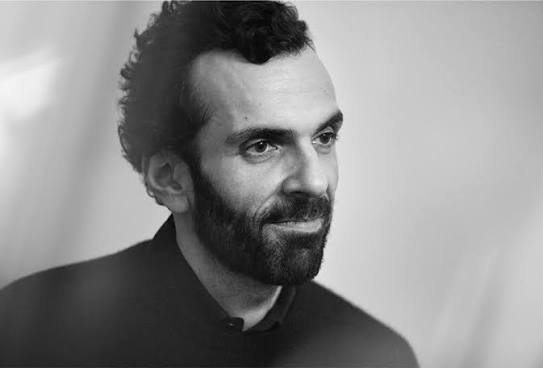 Black and white three-quarter portrait of Cédric Charbit smiling at a press event