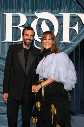 Cédric Charbit in a black tuxedo standing beside a guest in front of a backdrop marked BoF