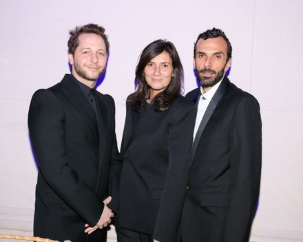 Cédric Charbit at the right of a group of three guests in dark tailoring at an evening event