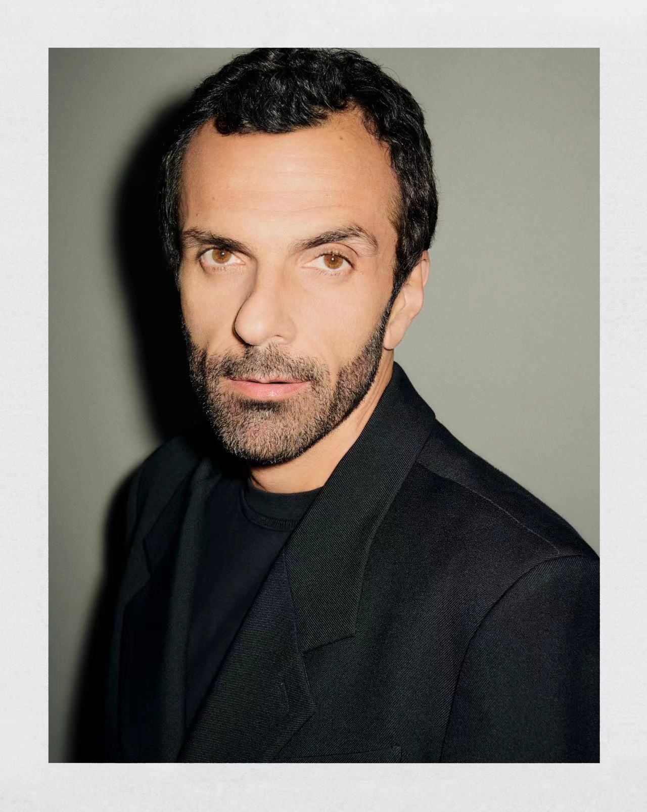 Studio portrait of Cédric Charbit, Chief Executive Officer of Saint Laurent, photographed against a muted olive background