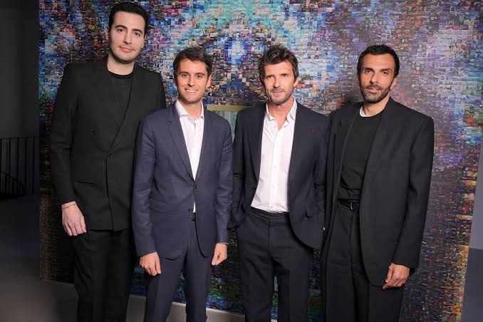 Cédric Charbit, at right, photographed with three other guests in front of a large illuminated screen at an industry event